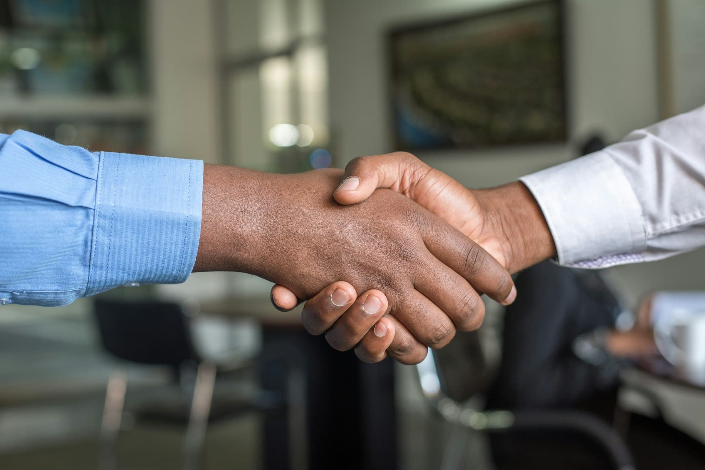 Two company directors shaking hands after an agreement, in an office