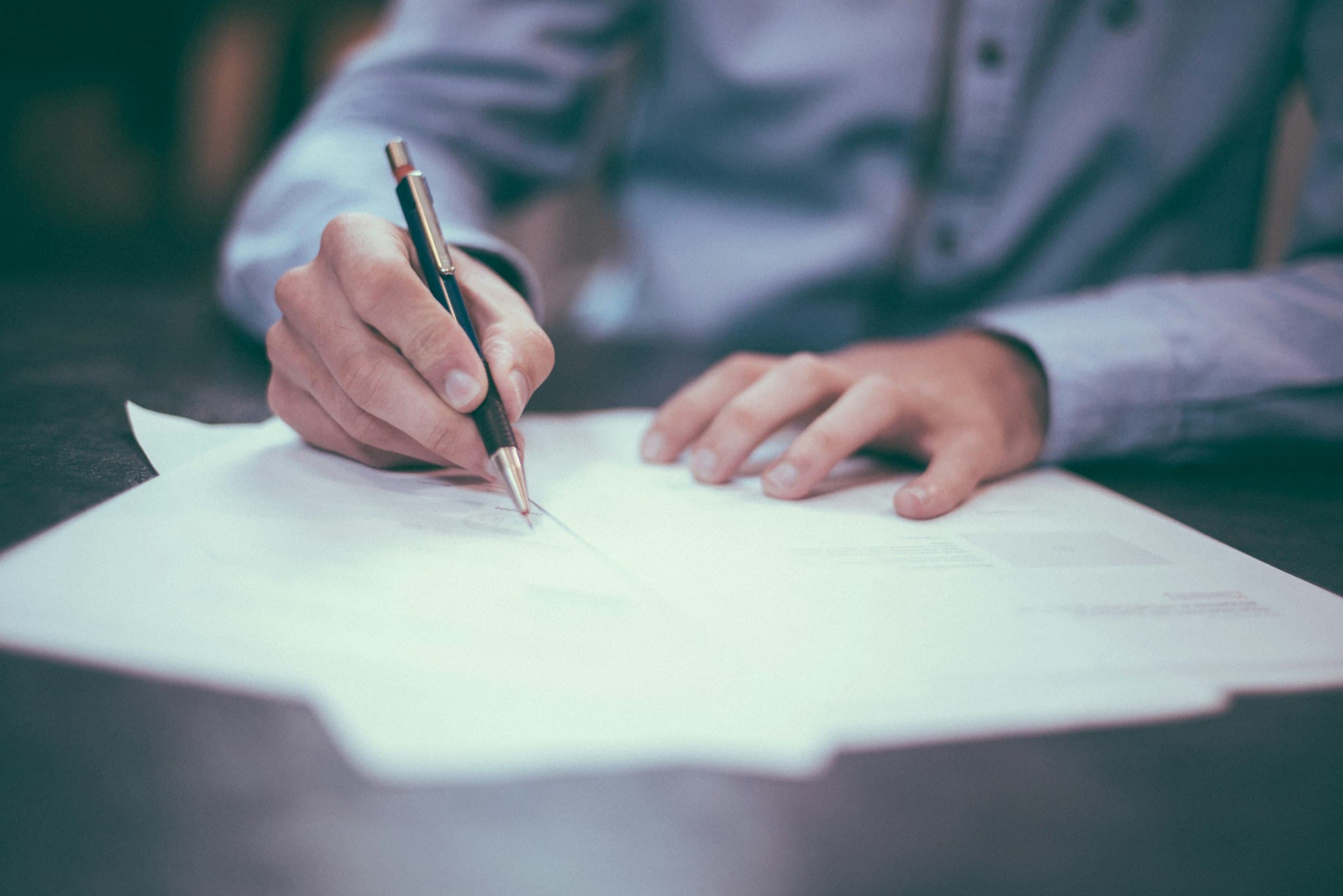 Signing a service contract, pen in hand