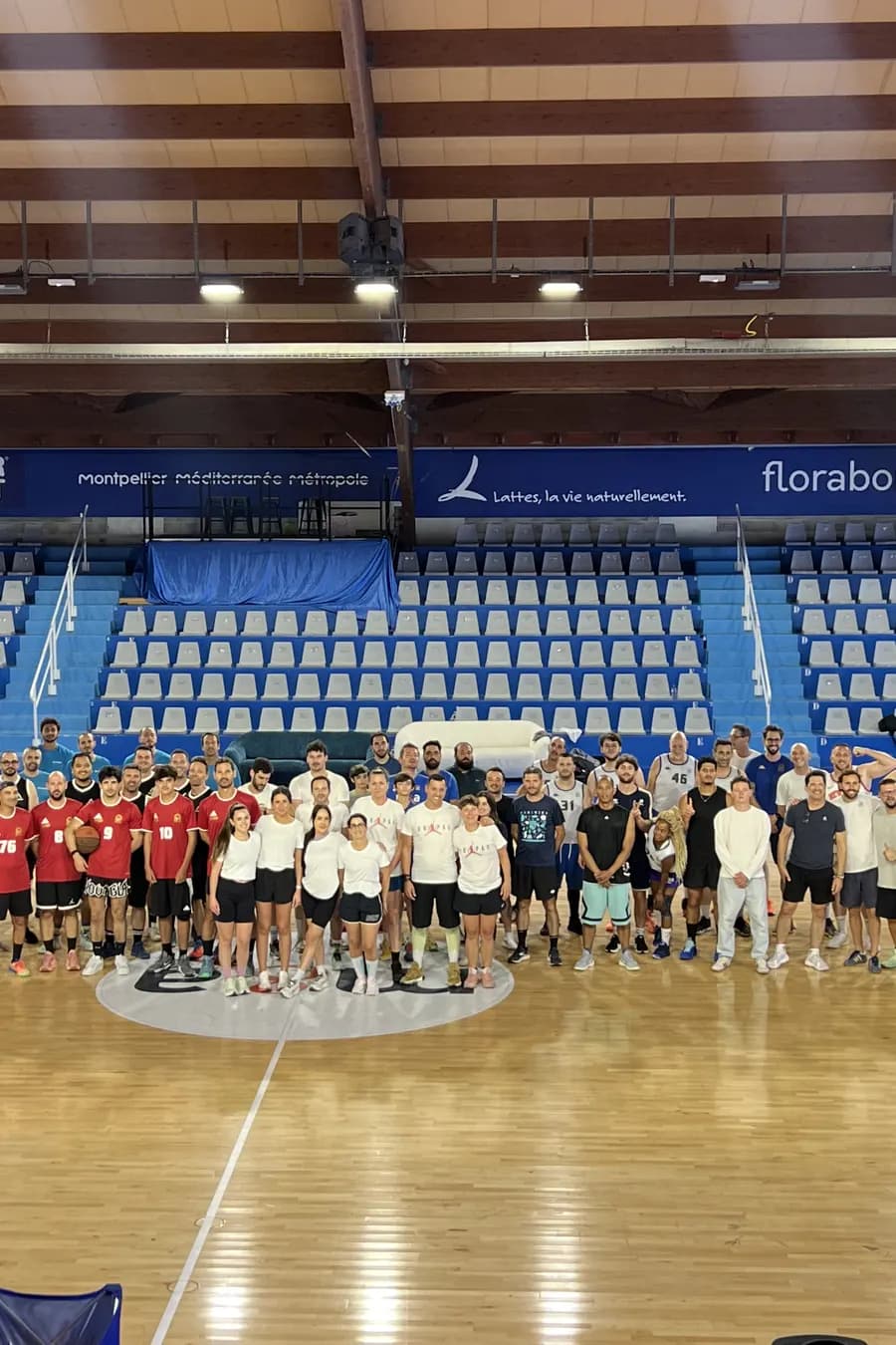 Foto di gruppo del torneo aziendale sul parquet del Palais des Sports